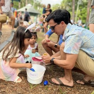 Dad helping daughters with easter eggs
